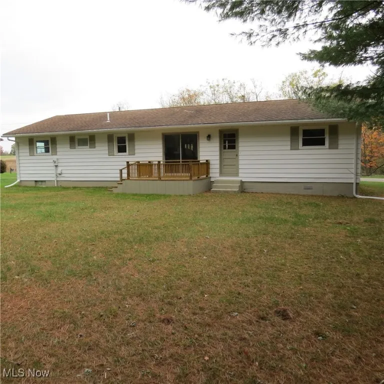 View of front of home featuring crawl space, a front yard, and a wooden deck