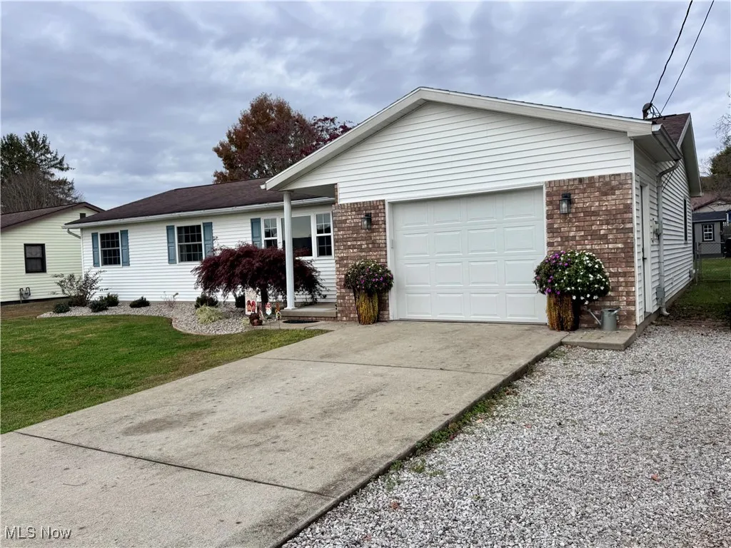 Ranch-style home with concrete driveway, brick siding, and a garage