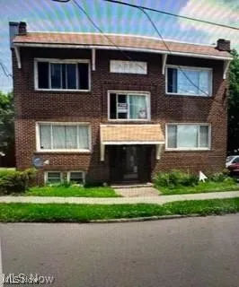 View of front of home with a chimney and brick siding