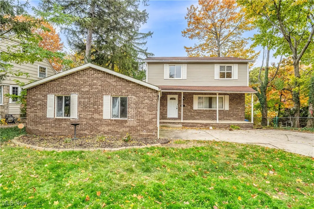 Traditional-style house with covered porch, a front lawn, and brick siding