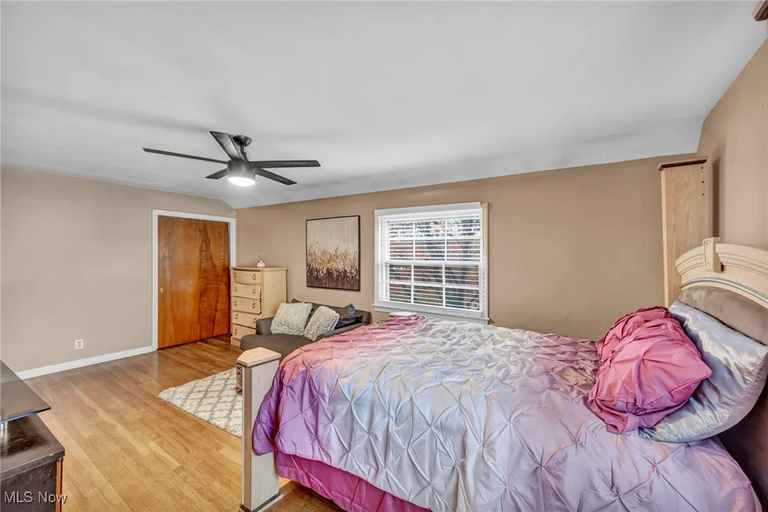Bedroom with light wood-type flooring, a closet, and ceiling fan
