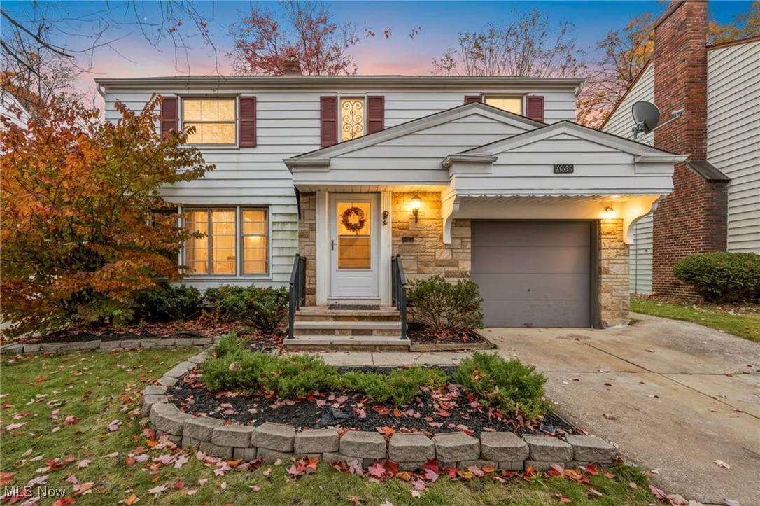 View of front of home featuring concrete driveway, an attached garage, and stone siding