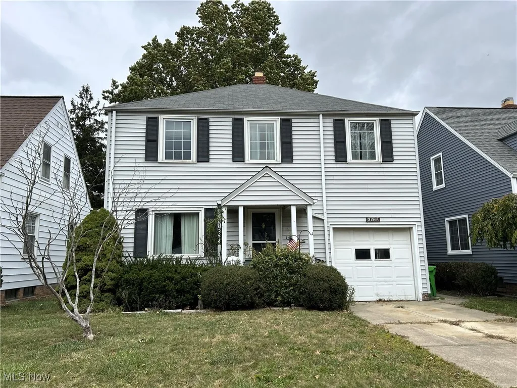 View of front of house with a garage, driveway, and a front lawn