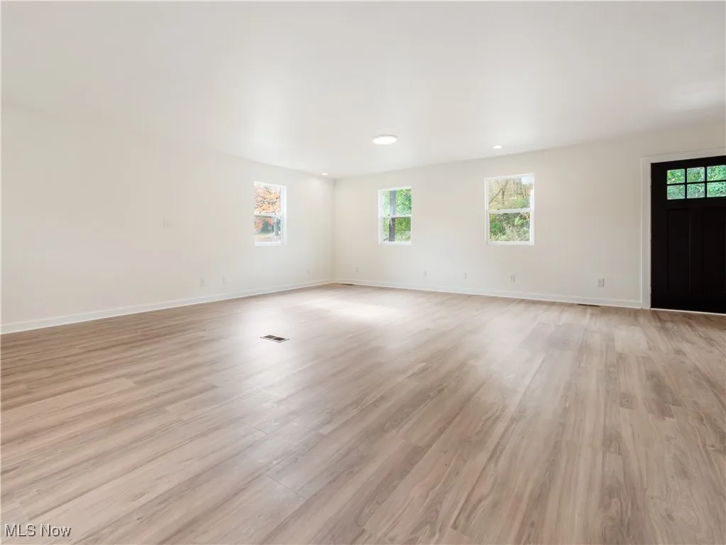 Unfurnished room with healthy amount of natural light, light wood-type flooring, and recessed lighting