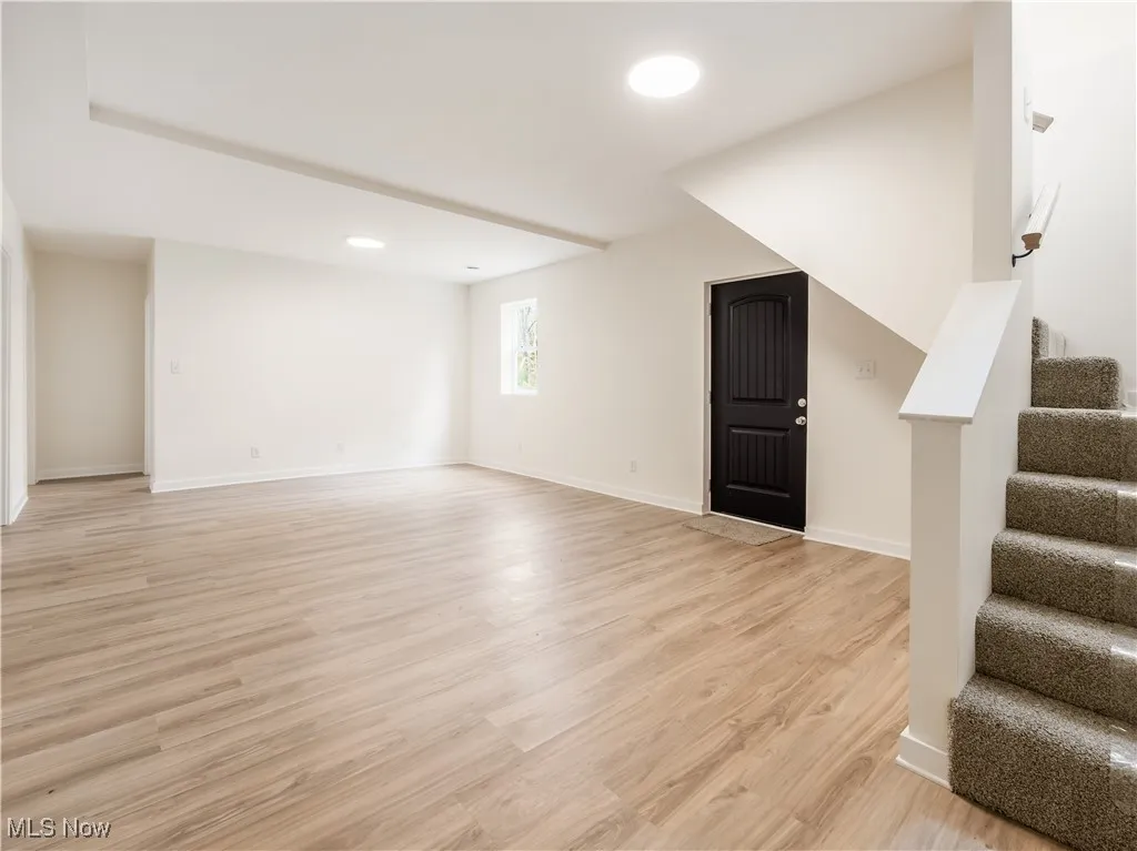 Below grade area featuring stairway, light wood-style flooring, and recessed lighting