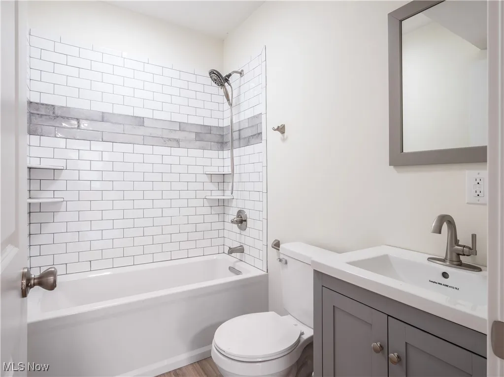 Full bathroom featuring shower / tub combination, vanity, and light wood-style floors