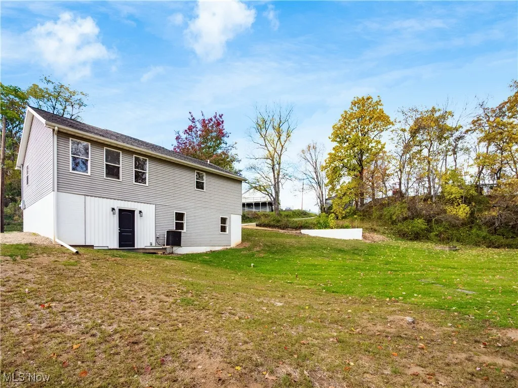 Rear view of house with a lawn and a patio area