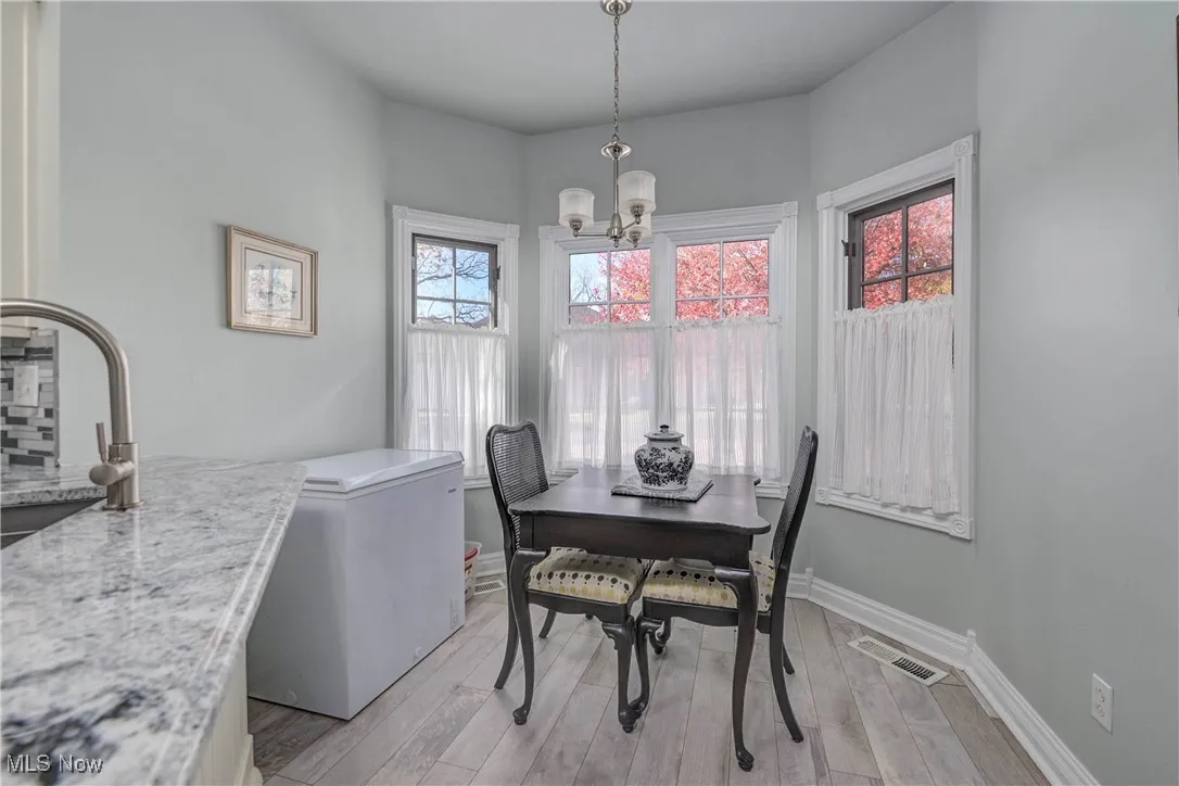 Dining area featuring light wood-type flooring and a chandelier