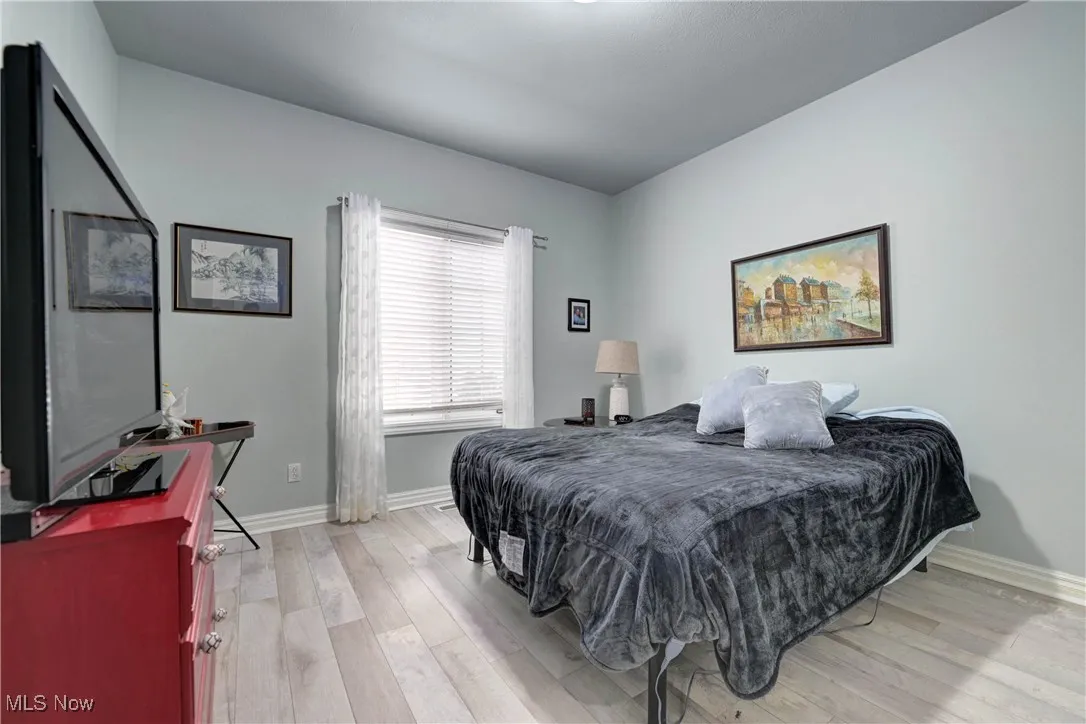 Bedroom with light wood-style floors and baseboards