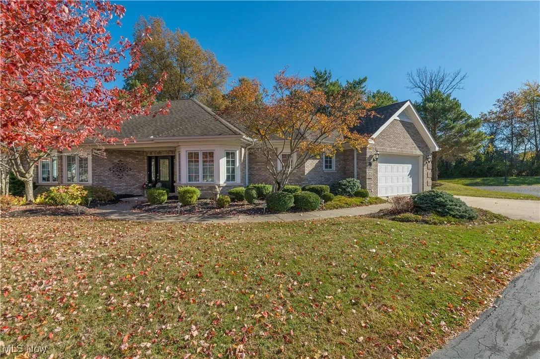 View of front of home featuring brick siding, a front lawn, an attached garage, concrete driveway, and a shingled roof