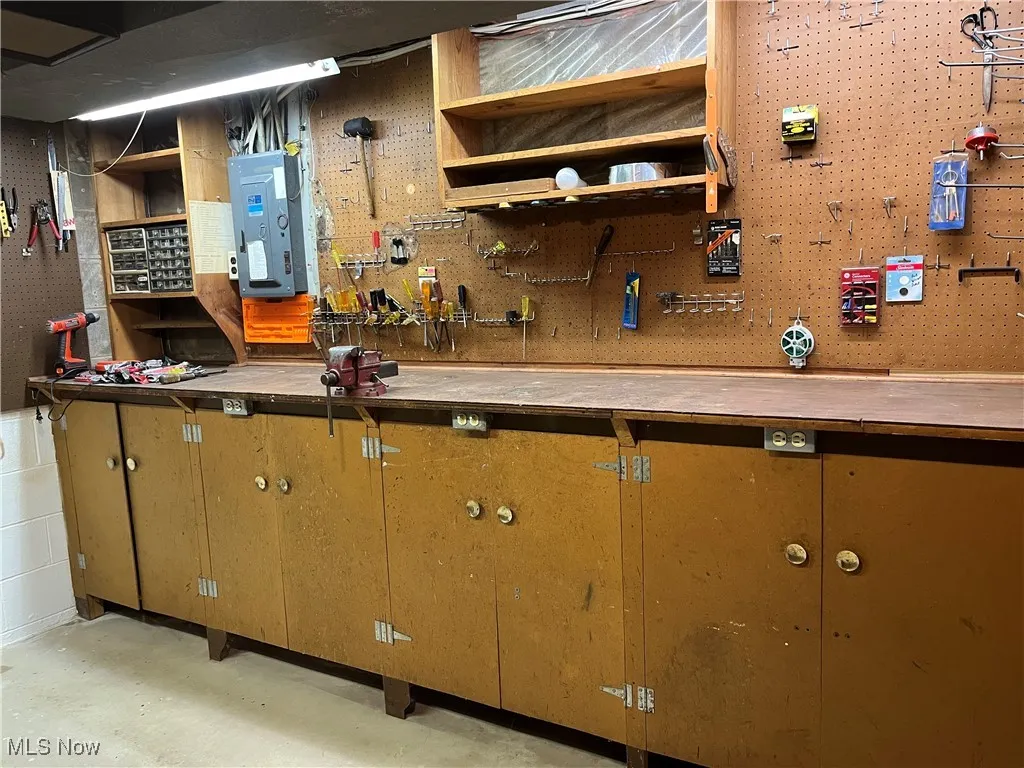 Bar featuring a workshop area, electric panel, and open shelves
