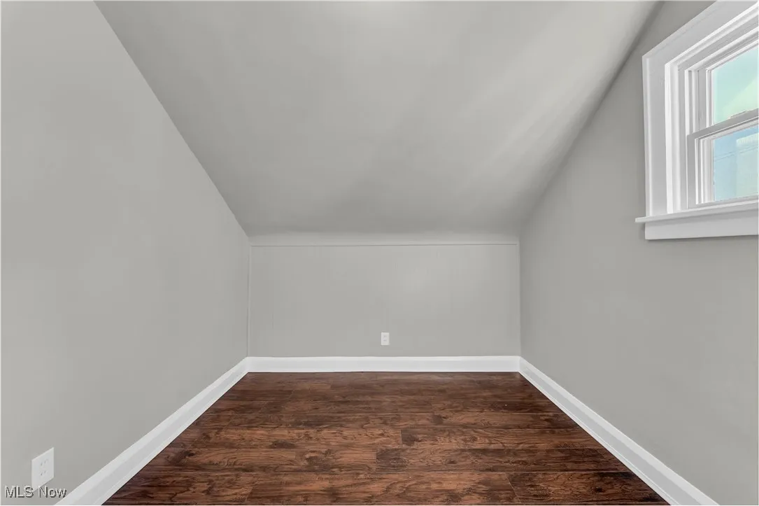 Bonus room featuring lofted ceiling and dark wood-style flooring