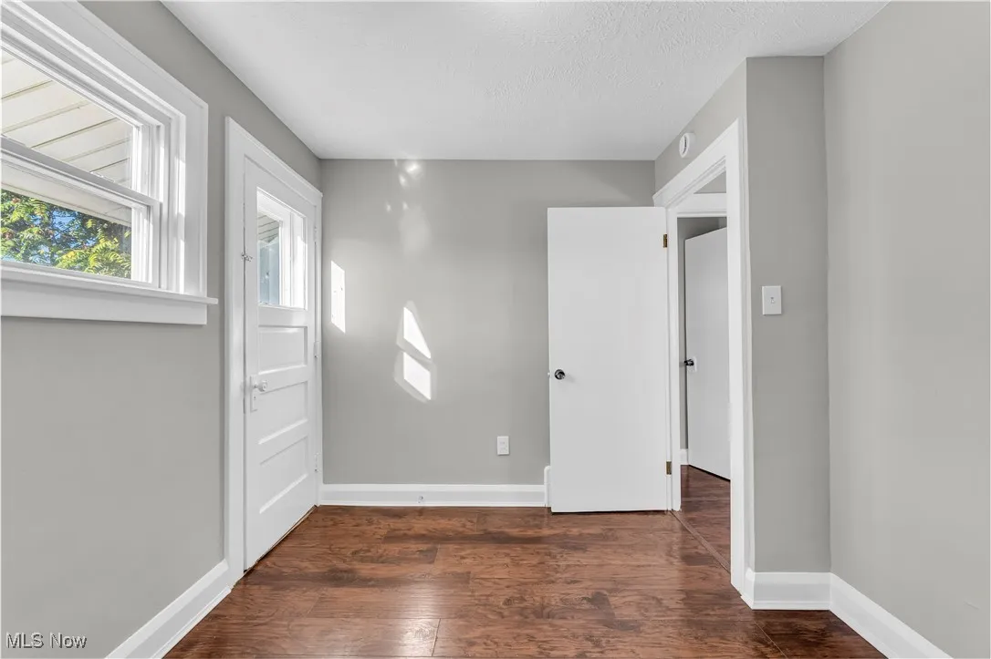 Foyer entrance with dark wood-type flooring and a textured ceiling