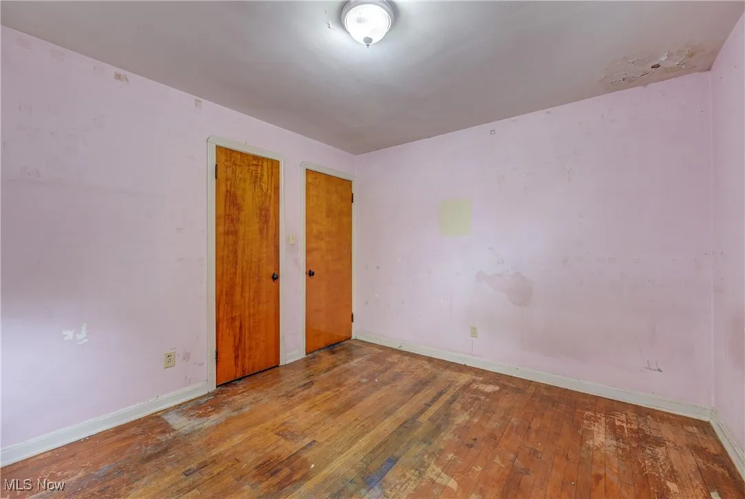 Unfurnished bedroom featuring wood-type flooring and baseboards