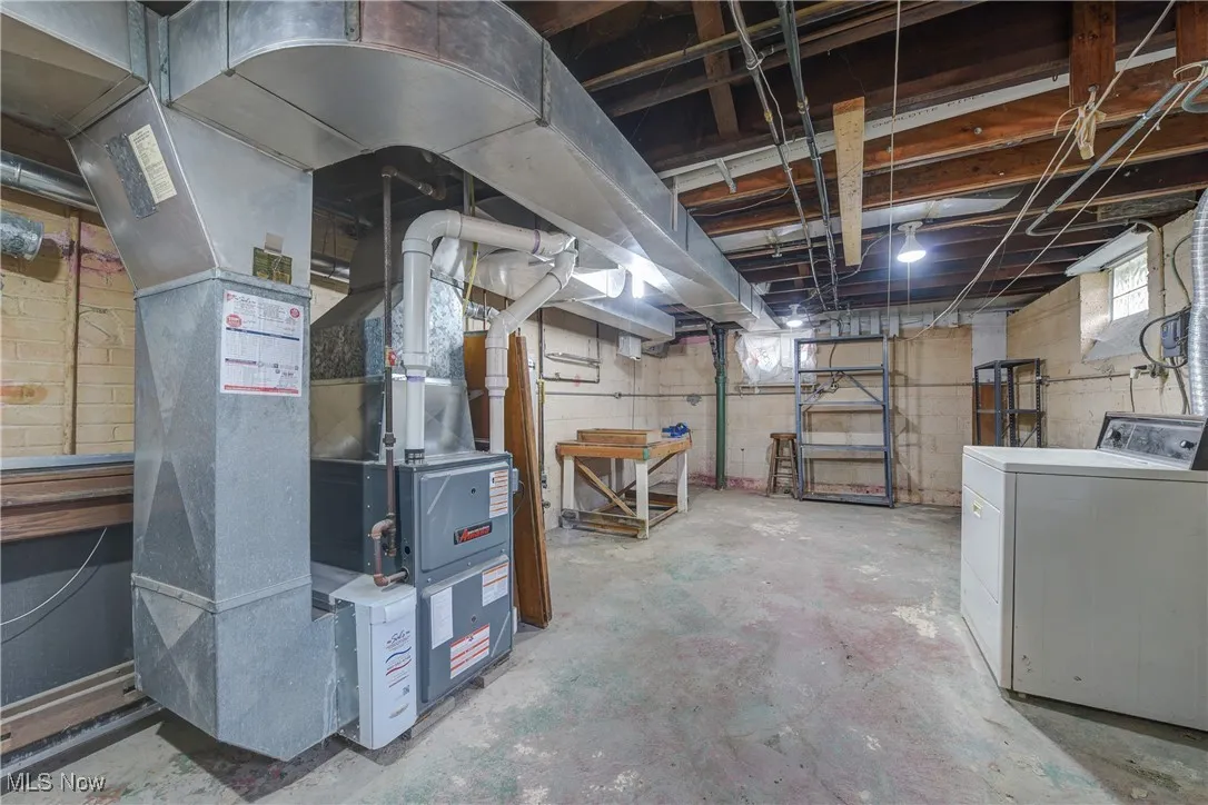 Basement featuring washer / clothes dryer and heating unit