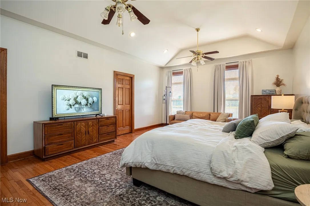 Bedroom featuring wood-type flooring, ceiling fan, lofted ceiling, and recessed lighting