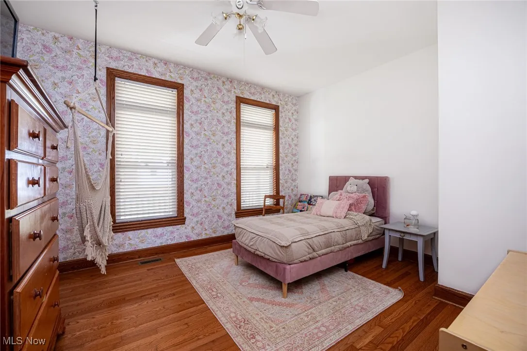 Bedroom with multiple windows, wood finished floors, and ceiling fan