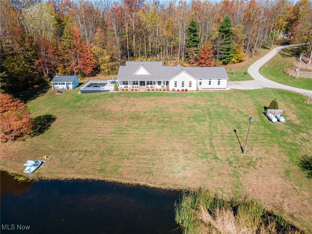 Aerial view of property and surrounding area with a large body of water