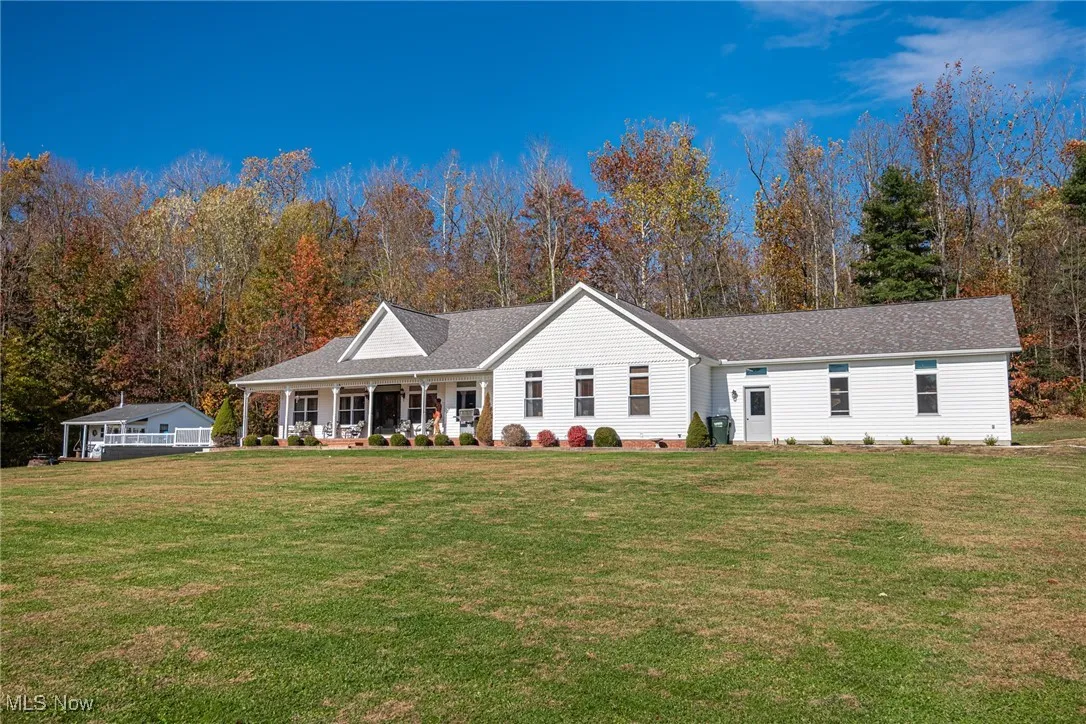 Single story home with covered porch, a front lawn, and a shingled roof