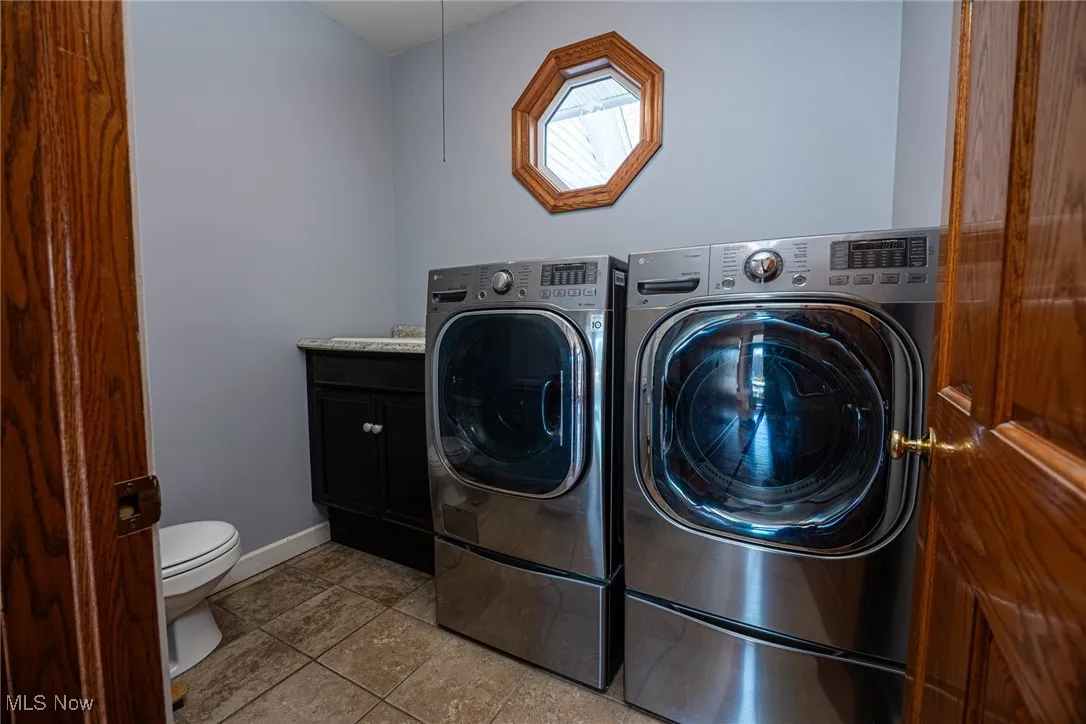 Laundry room featuring separate washer and dryer and light tile patterned floors