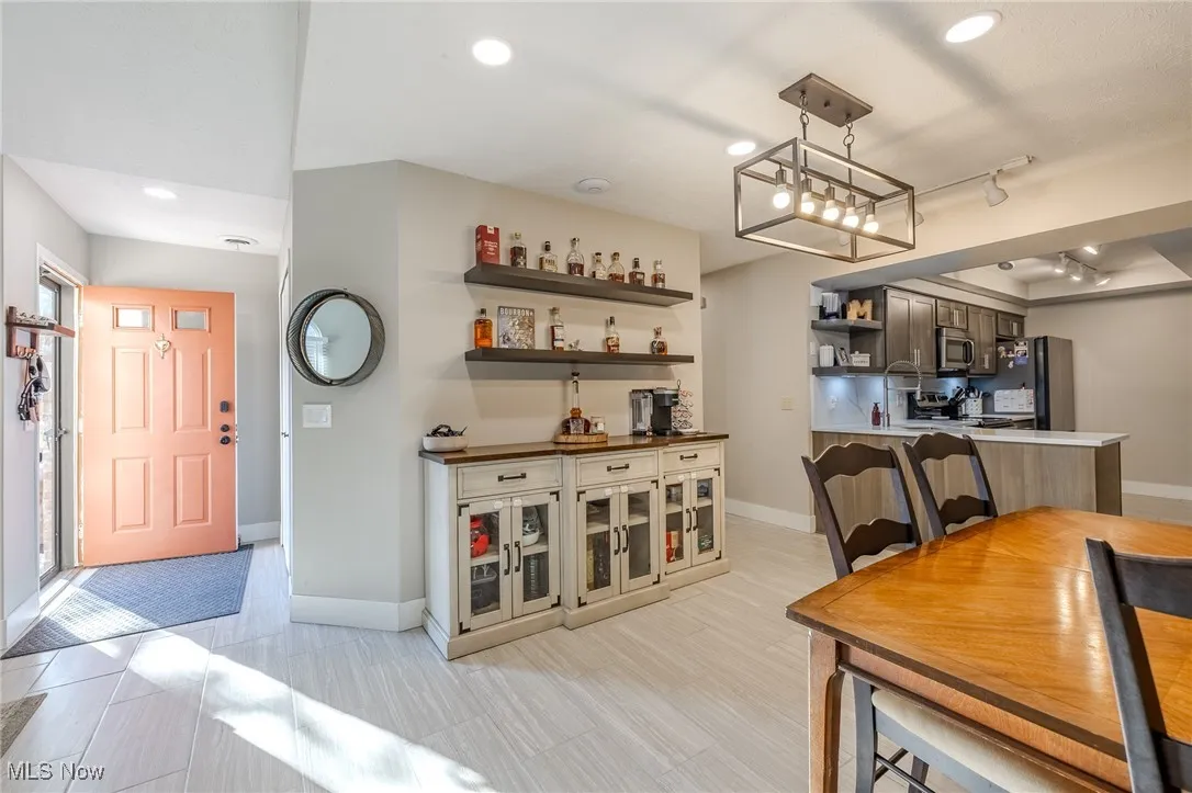 Bar featuring recessed lighting, stainless steel appliances, rail lighting, open shelves, and pendant lighting