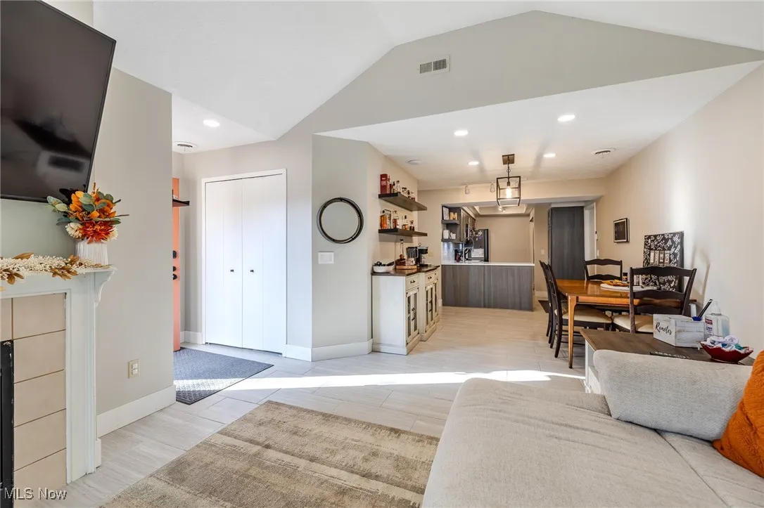 Living area with recessed lighting, wood finish floors, and lofted ceiling