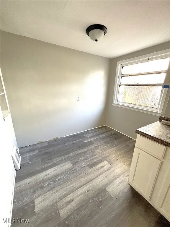 Unfurnished dining area with dark wood-style floors