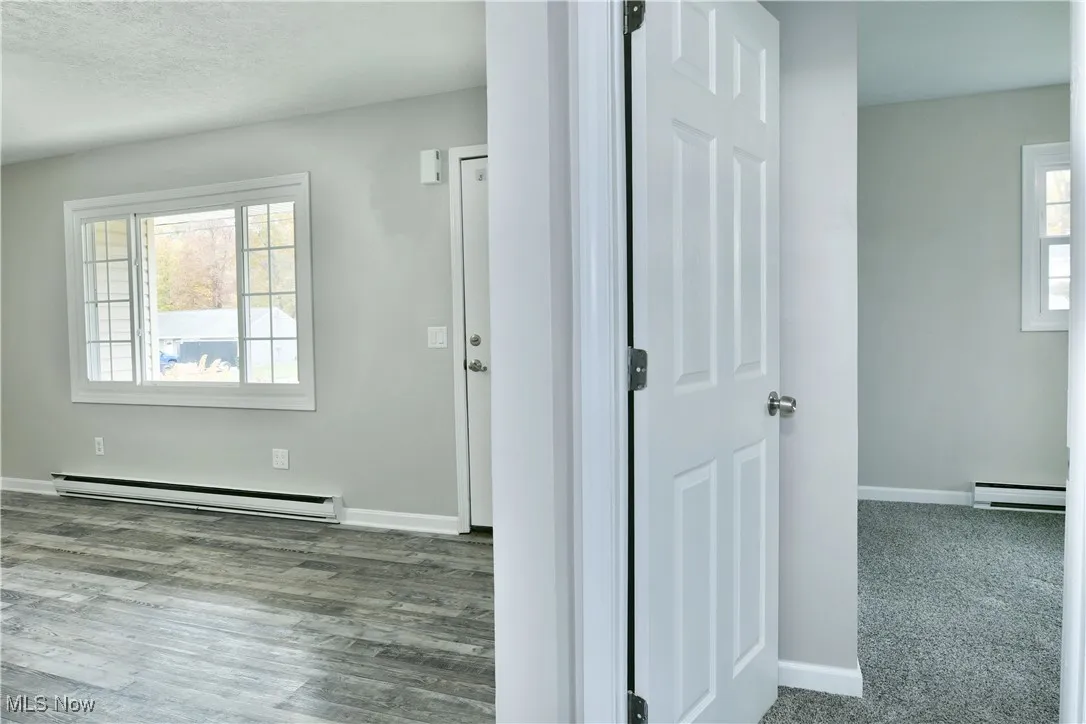 Foyer featuring a baseboard radiator, a baseboard heating unit, and wood finished floors