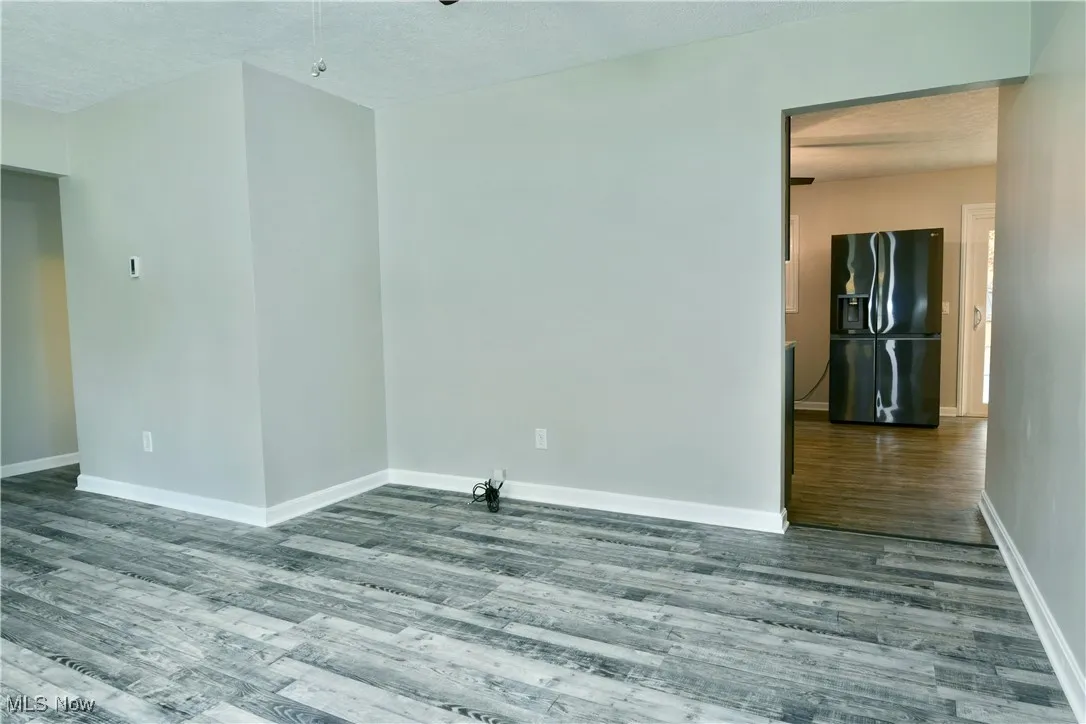 Spare room featuring a textured ceiling, wood finished floors, and ceiling fan