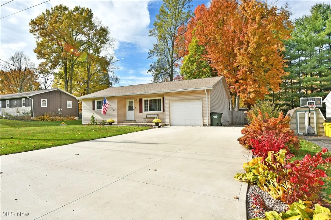 Ranch-style house featuring a garage, driveway, and a front yard