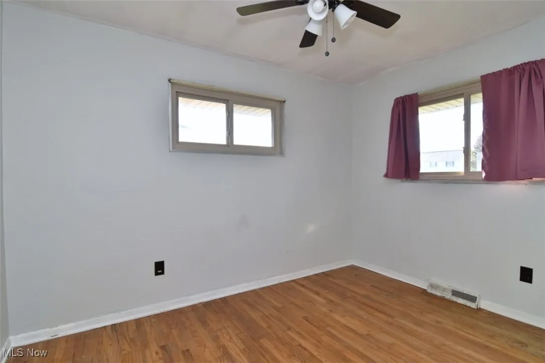 Empty room featuring light wood-type flooring and a ceiling fan