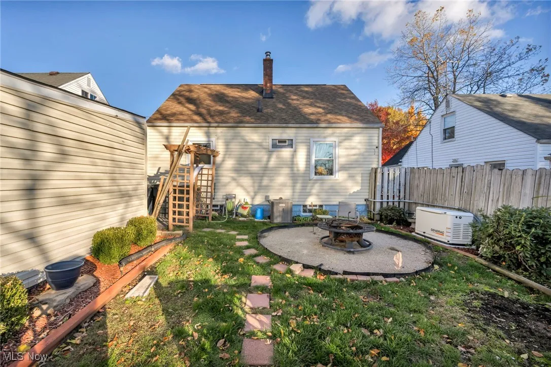 Back of property featuring a patio area, a chimney, and an outdoor fire pit