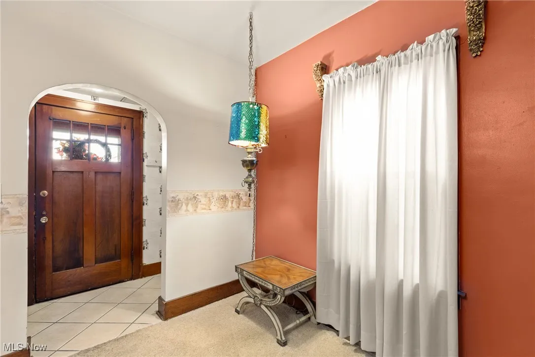 Entryway featuring arched walkways and light tile patterned flooring