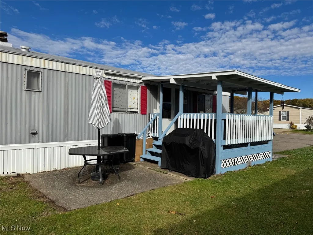 Side of house with a yard and a porch.