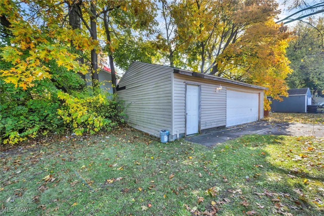 Detached garage featuring view of wooded area