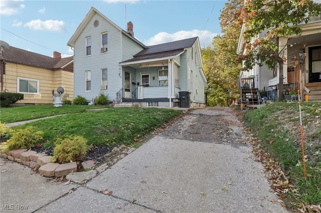 View of front of property featuring a porch, a front lawn, and a chimney