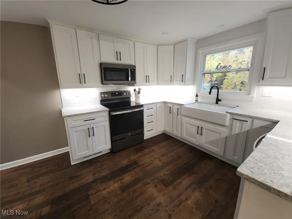 Kitchen with decorative backsplash, all new stainless steel appliances stay, Quartz countertop, white cabinets, the cabinets are all soft close.  Farmers sink with garbage disposal.