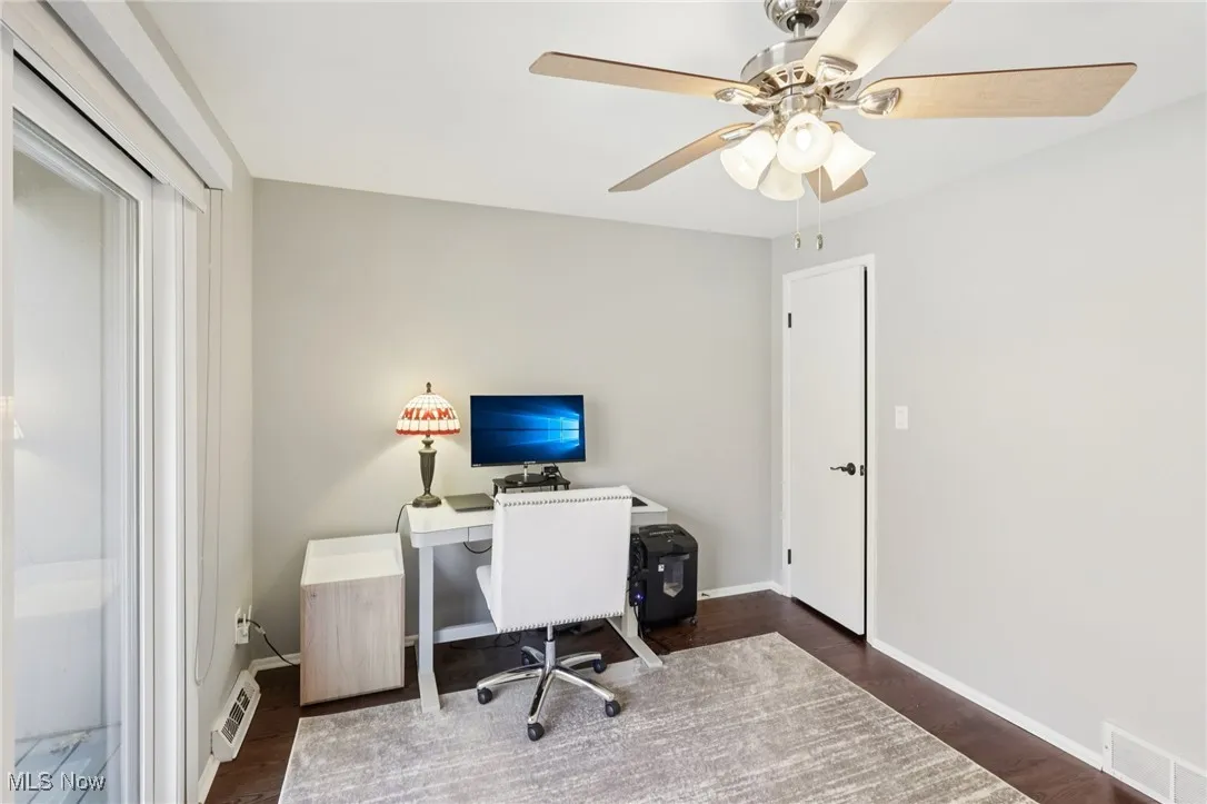 Office area featuring dark wood-type flooring and baseboards