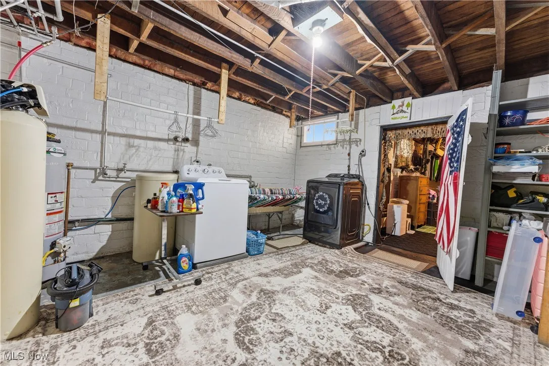 Below grade area featuring a water softener system and washing machine and clothes dryer