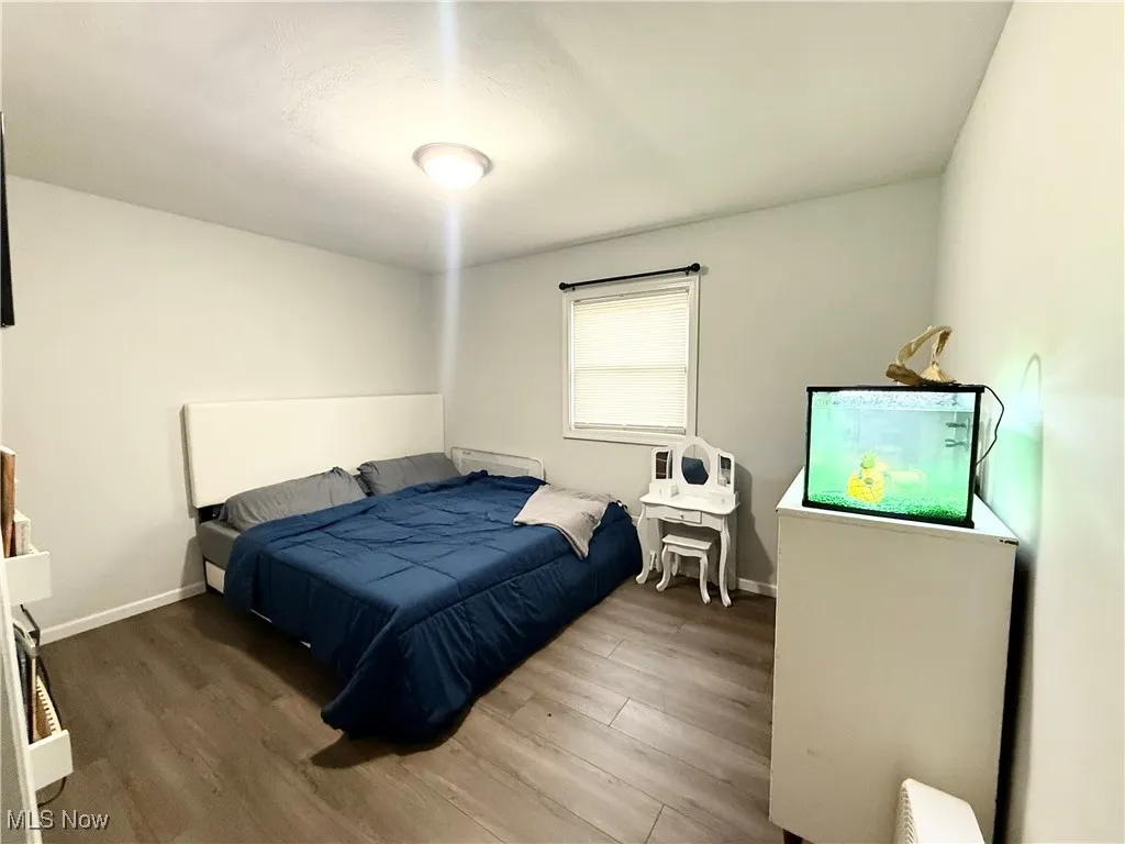 Bedroom with wood finished floors and baseboards