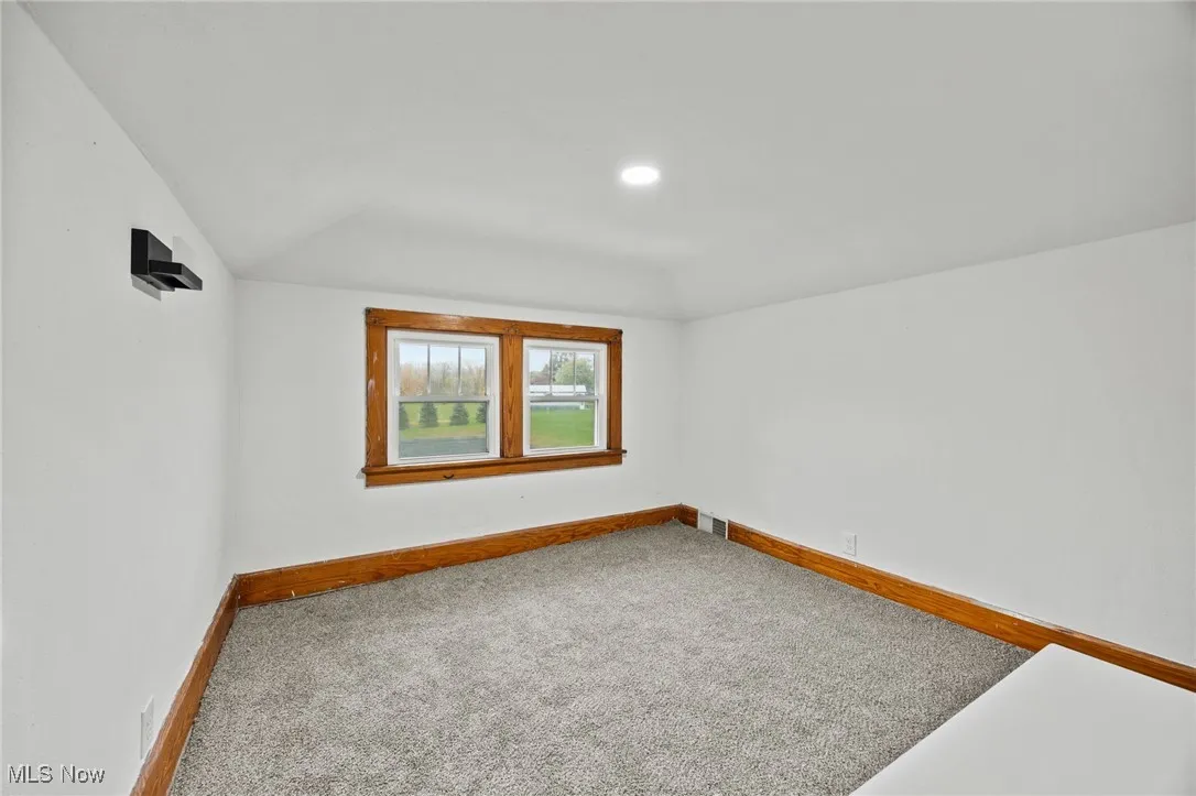 Unfurnished room with carpet flooring, lofted ceiling, and recessed lighting