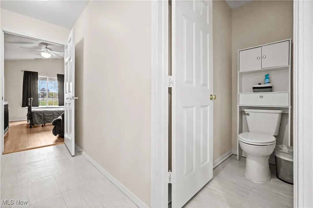 Ensuite bathroom featuring light tile patterned flooring and ceiling fan