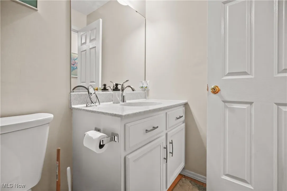 Half bathroom with vanity and toilet