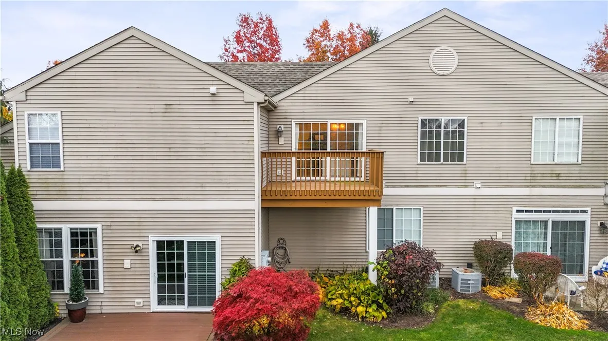 Back of house featuring a balcony and a shingled roof