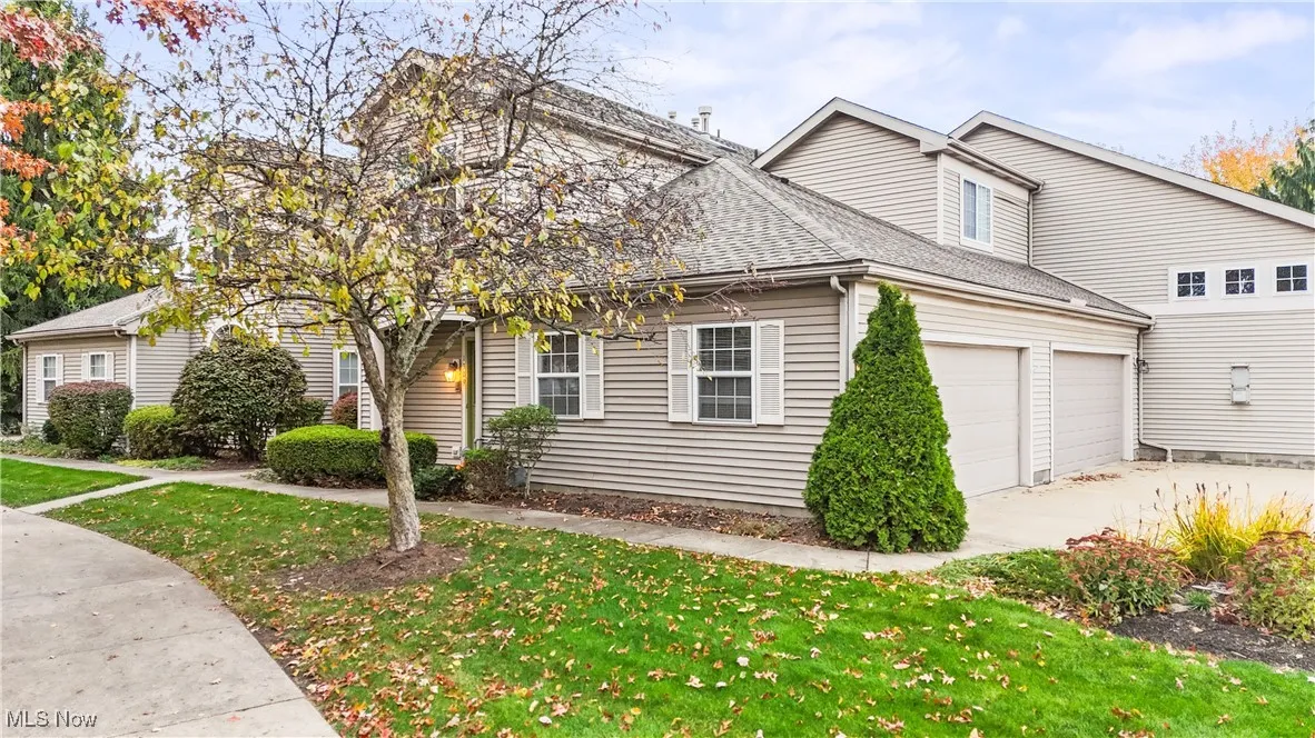 View of front of property with a shingled roof and a front lawn