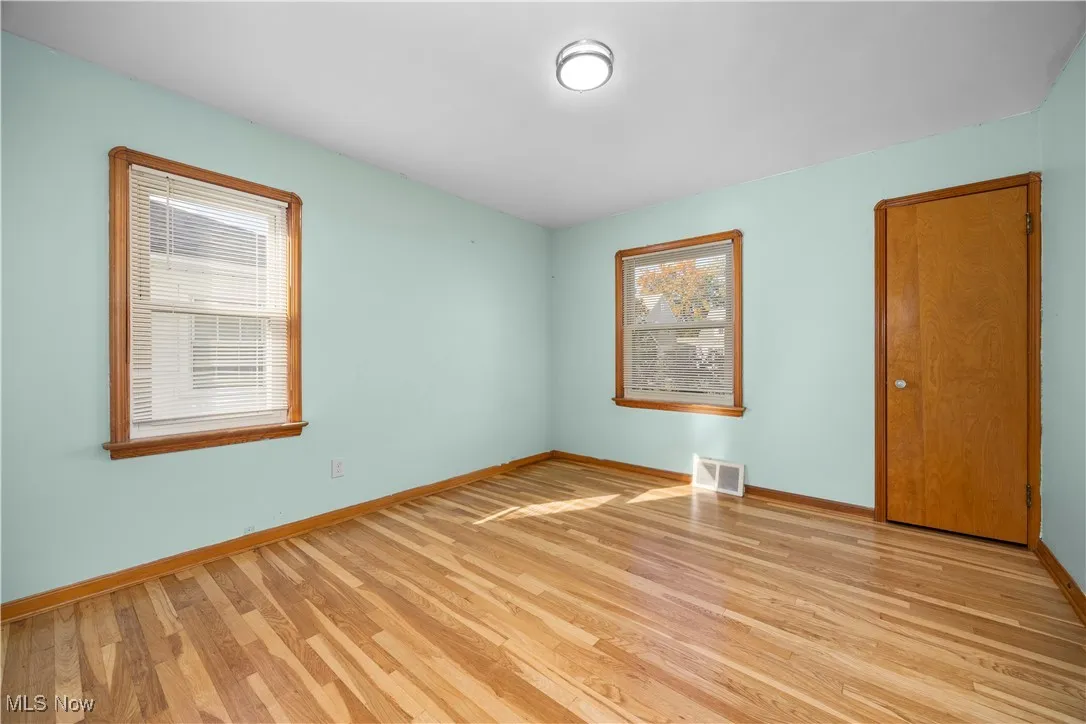 Unfurnished room featuring light wood finished floors and baseboards