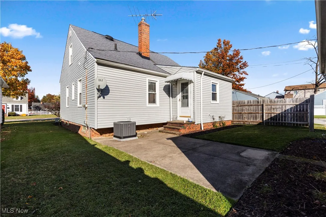 Rear view of property featuring a patio area, a chimney, a shingled roof, and entry steps