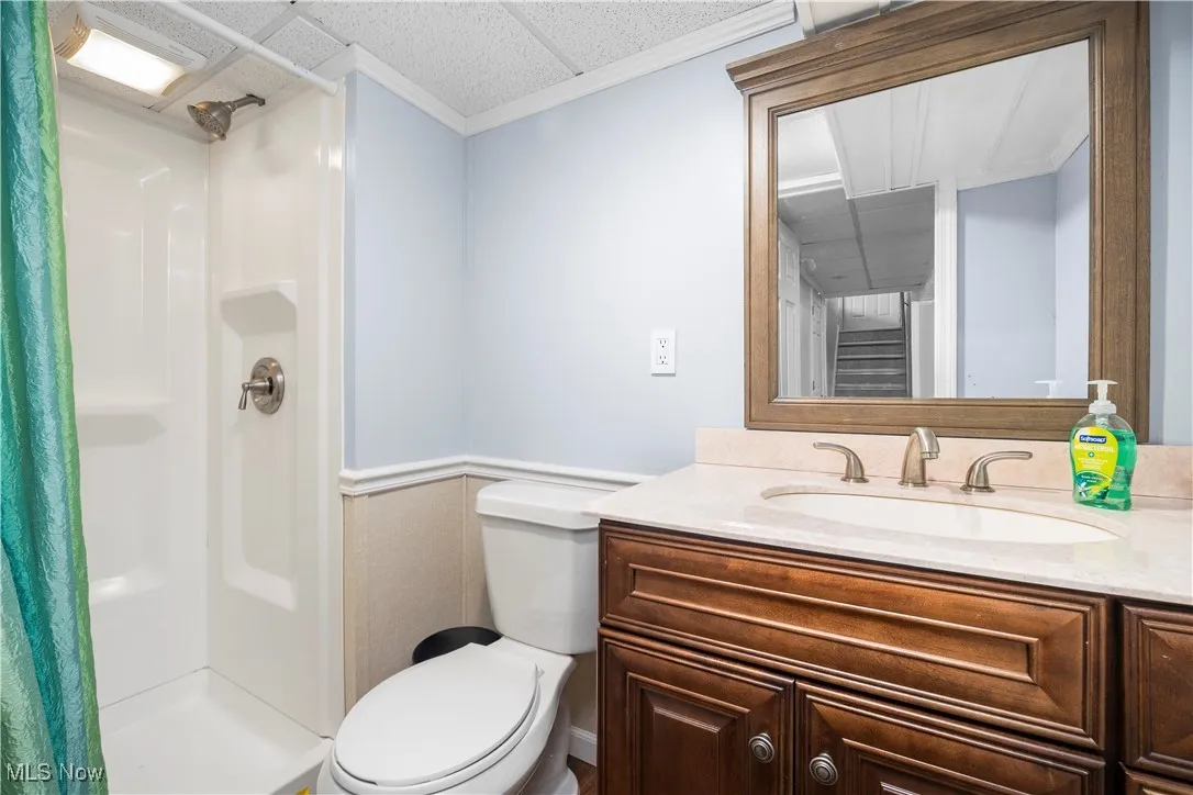 Bathroom featuring vanity, a shower with curtain, and crown molding