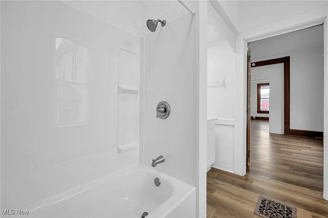 Full bathroom featuring shower / bathtub combination and wood finished floors