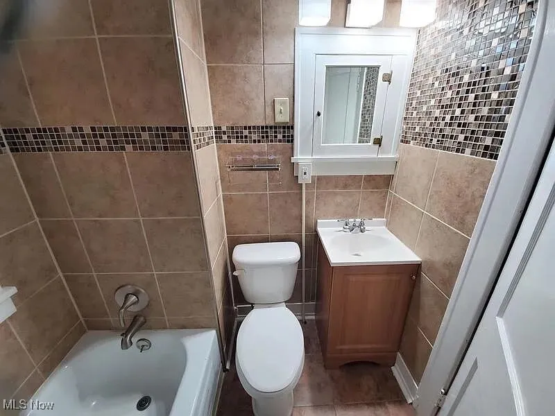 Bathroom featuring tile walls and vanity